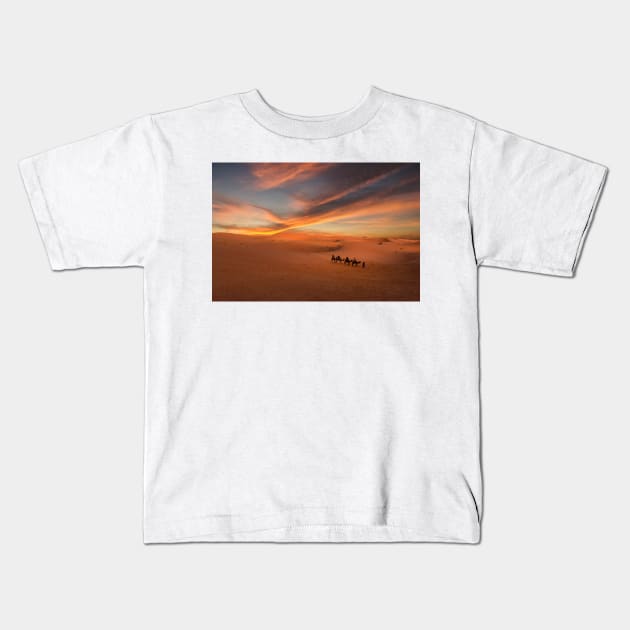 Camel caravan in Sahara desert at sunset Kids T-Shirt by mitzobs